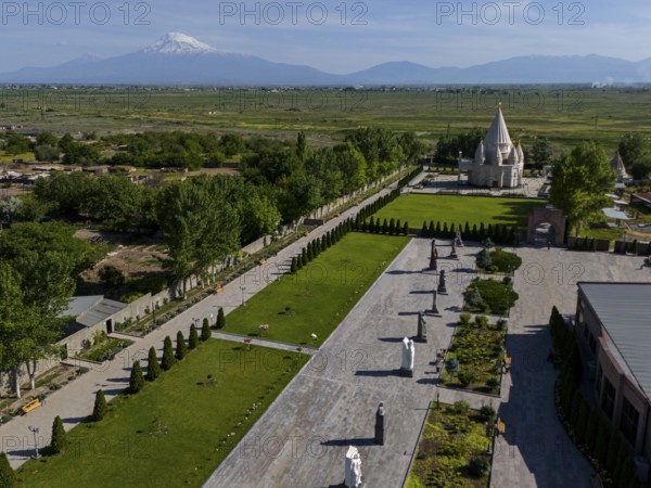 Spacious garden with statues and temple, surrounded by nature and mountains in the distance, aerial view, Yazidi temple, the largest Yazidi temple in the world is called Quba Mere Diwane, Aknalich, Aknalitsch, Armavir district, in the background Mount Aarat in Turkey, Armenia