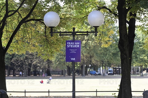 Posters for the North Rhine-Westphalia municipal election campaign in Bonn around the Hofgarten in the university district. Poster by Volt with the inscription Woman at the wheel