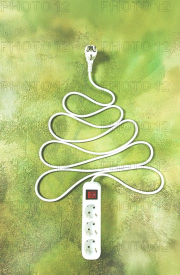 A power strip is arranged in the shape of a Christmas tree, artistically placed on a vibrant green and yellow backdrop. The design adds a playful touch to the festive atmosphere