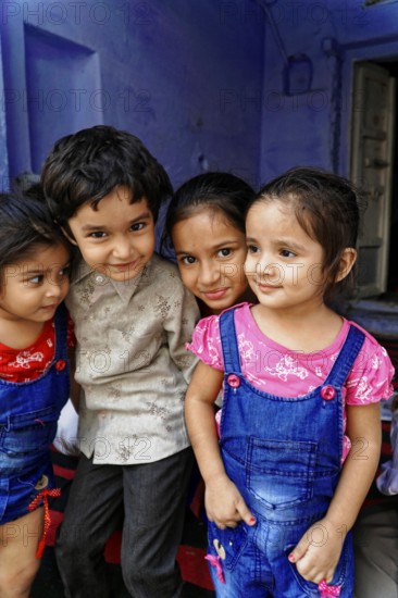 Udaipur, Rajasthan, North India, Asia, Four children pose close to each other, smiling and showing close friendship