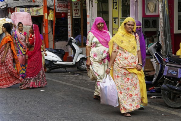 Udaipur, Rajasthan, North India, Asia, Women in traditional saris shopping on an Indian street