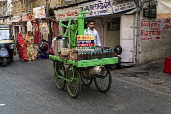 Udaipur, Rajasthan, North India, Asia, Man with traditional juice cart on busy street corner