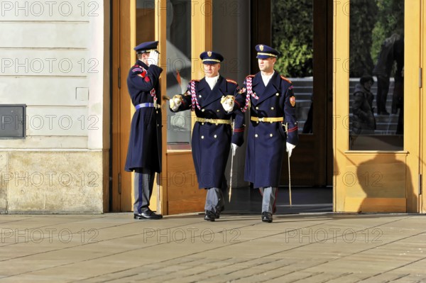 Changing of the guard at Prague Castle, Hradcany, Prague, Czech Republic, Europe, Soldiers in blue uniforms leave a building through large wooden doors