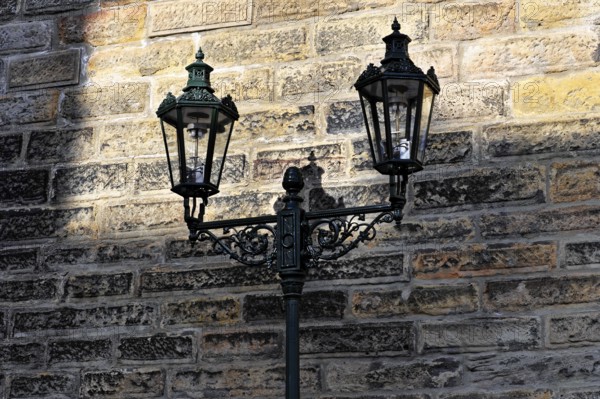 Prague, Czech Republic, Europe, vintage-style wall lantern casts shadows on a stone wall