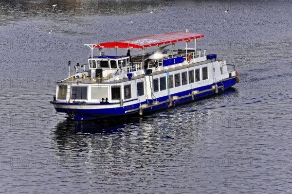 Prague, Czech Republic, Europe Passenger boat with a red roof on a calm river, Europe