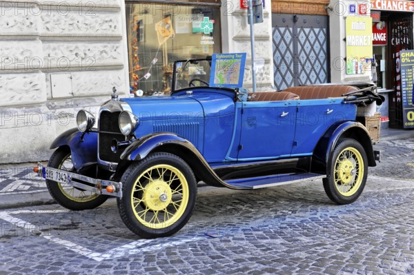Prague, Czech Republic, Europe, Blue vintage car with open seats, standing decoratively on a cobbled street