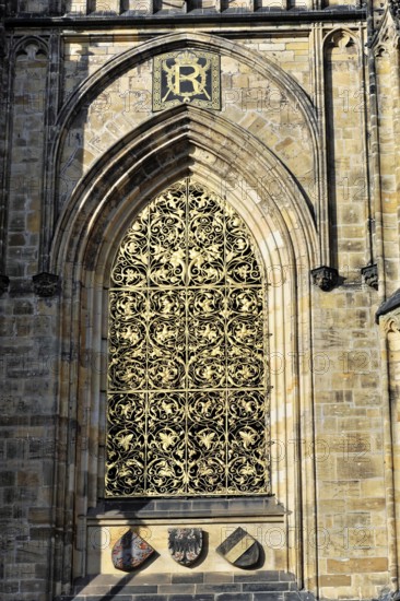 St Vitus or St Vitus Cathedral, Hradcany, Prague, Czech Republic, Europe, Barred Gothic window with rich decorations and coats of arms in the sunshine