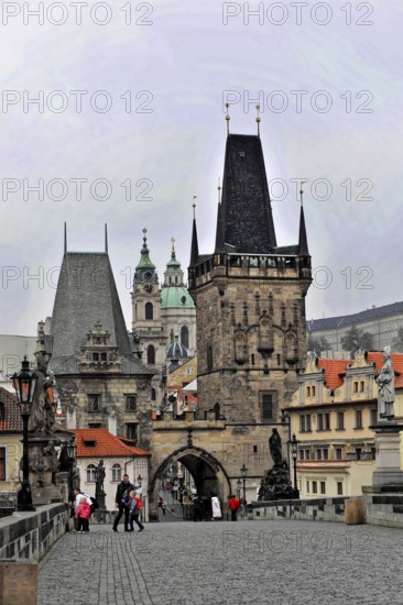 Prague, Czech Republic, Europe, Old stone bridge with imposing towers and buildings in the distance