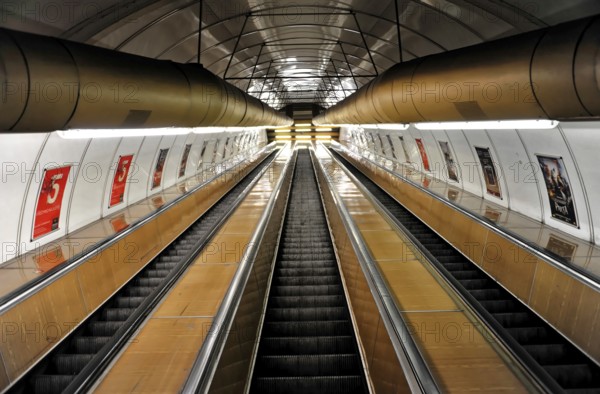 Long escalators in a modern underground station with futuristic lighting, Prague, Czech Republic