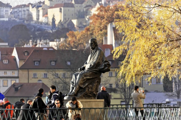 Smetana Monument, Prague, Czech Republic, Europe, A bronze statue sits in the foreground framed by autumnal trees and visiting people