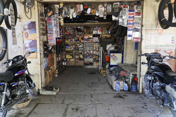 Kota, Rajasthan, North India, Asia, A small workshop shop with motorbike parts, tools and shelves full of spare parts, India