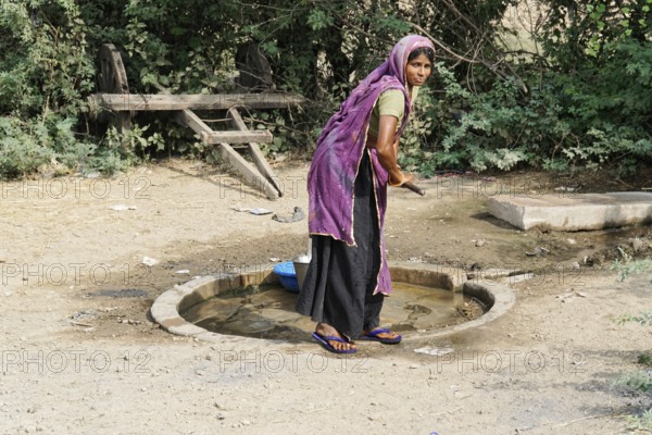 Kota, Rajasthan, North India, Asia, Woman drawing water at a traditional rural waterhole, India