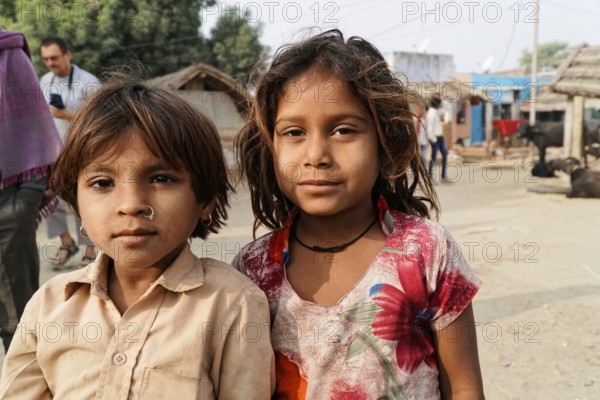 Sawai Madhopur, Kota, Rajasthan, North India, Asia, Two children in a village, looking seriously into the camera. Rustic environment in the background, India