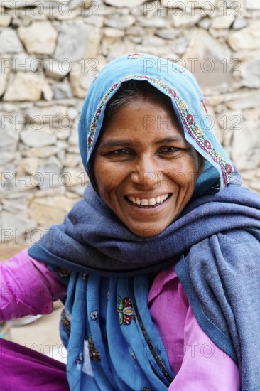 Sawai Madhopur, Kota, Rajasthan, North India, Asia, Woman in blue and pink clothes smiling with a headscarf and shawl, India