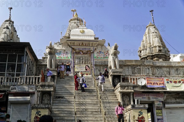 Entrance to Jagdish Temple, Udaipur, People climb the steps to a temple flanked by statues under a clear sky, Rajasthan, North India, India, Asia, A magnificent temple with steps used by several visitors