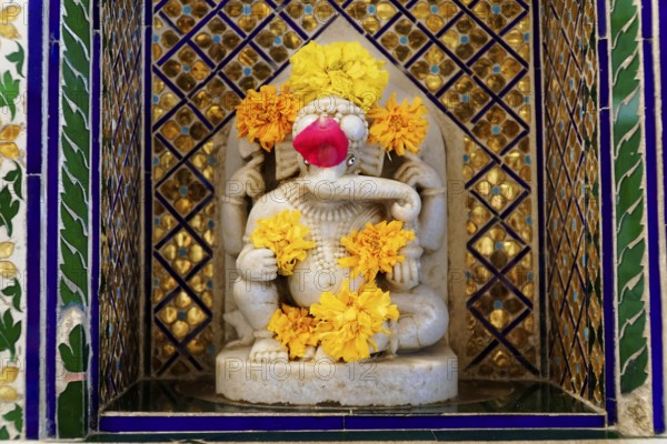 City Palace, Udaipur, Rajasthan, India, Asia, Marble statuette of Ganesha, adorned with flowers, in a traditionally decorated frame, North India