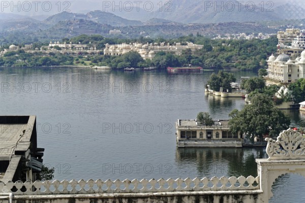 City Palace, Udaipur, Rajasthan, India, Asia, View over a lake with palaces and mountains in the distance in an Indian city, North India