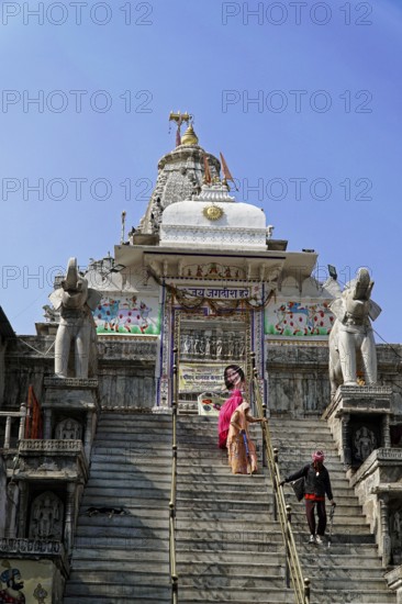 Entrance to Jagdish Temple, Udaipur, People climb the steps to a temple flanked by statues under a clear sky, Rajasthan, North India, India, Asia, An important temple with monumental stairs and a spiritual attraction