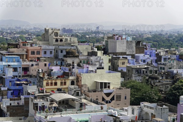 Udaipur, Rajasthan, North India, Asia, View of a building in India with a multitude of colourful houses in front of a hill