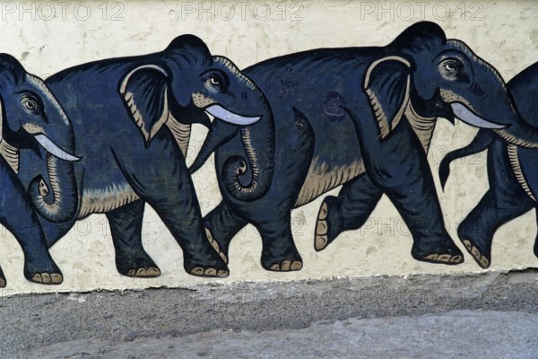 Udaipur, Rajasthan, North India, Asia, Row of painted black elephants on a light-coloured wall, walking in one direction