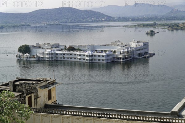 Lake Pichola overlooking Lake Palace, Udaipur, Rajasthan, India, Asia, Palace on a lake surrounded by hills and water in a tranquil setting, North India