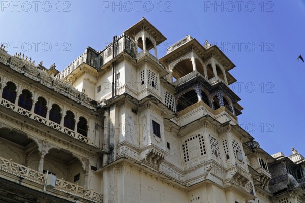 Udaipur, Rajasthan, North India, Asia, White palace with ornate traditional windows and blue sky in the background