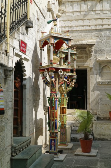 Udaipur, Rajasthan, North India, Asia, Indian temple architecture with elaborate sculptures and plants in an inner courtyard