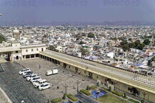 City Palace, Udaipur, Rajasthan, India, Asia, City view with a large square and parked cars in front of a palace, North India