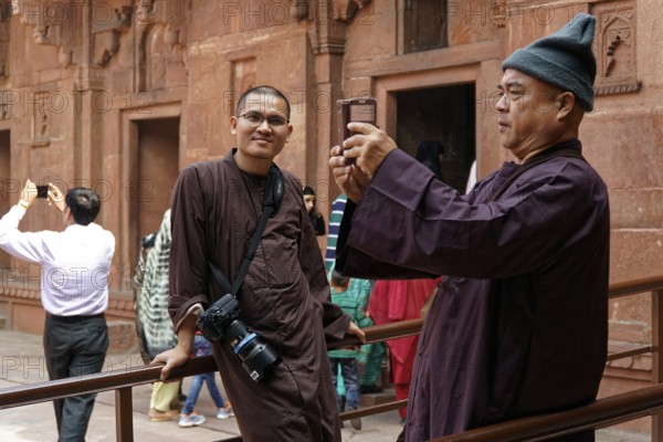Man taking photos with smartphone in historical surroundings, Agra, Jodhpur, Rajasthan, North India