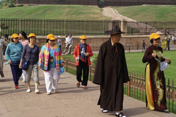 Group of tourists with yellow hats walking through a historical site, Agra, Jodhpur, Rajasthan, North India