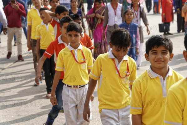 Group of children in yellow school uniforms standing happily in a row, Agra, Jodhpur, Rajasthan, North India