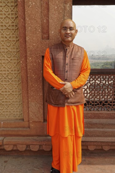 Agra, Uttar Pradesh, India, Asia, A monk in orange-coloured clothes stands in front of a historical wall, Jodhpur, Rajasthan, North India