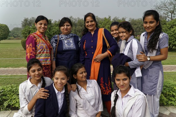 Group of female teachers and students in colourful clothes posing smiling outdoors, Agra, Jodhpur, Rajasthan, North India