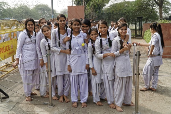 Girls in uniforms stand close together behind a protective fence, Agra, Jodhpur, Rajasthan, North India