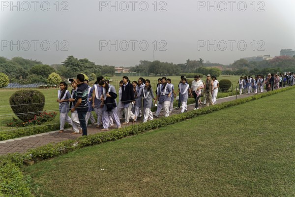 Agra, Jodhpur, Rajasthan, North India, Asia, A large group of people in uniforms walk along a path through a green park