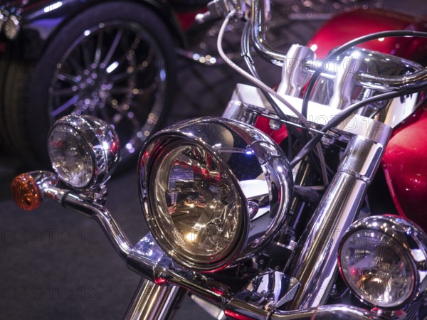 Retro motorbike with shiny chrome headlights and reddish finish, light reflections visible, dortmund, deutchland