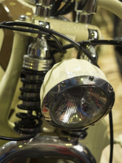 Vintage-style headlight on a cream-coloured motorbike with chrome details, dortmund, deutchland