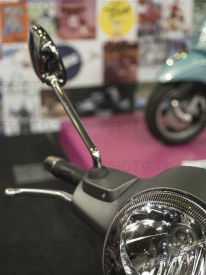 Mirror of a retro scooter in the foreground with colourful posters in the blurred background, dortmund, deutchland