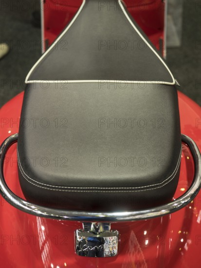 Black motorbike seat with white stitching on red base and chrome handle, dortmund, deutchland