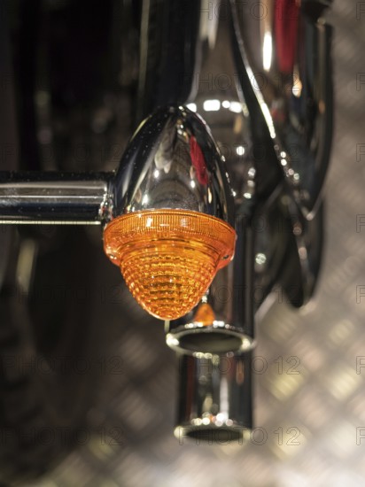 Close-up of an orange motorbike indicator with chrome details, dortmund, deutchland