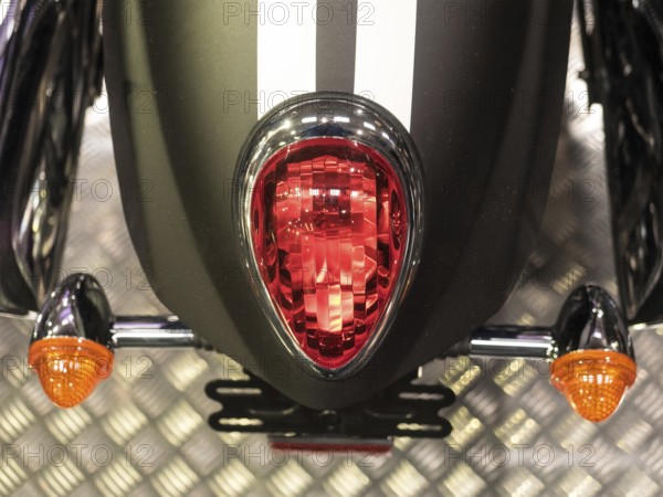 Red tail light with black stripes and orange indicators on metal base, dortmund, deutchland
