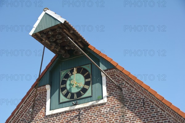 A large clock on a brick building under a clear sky, südlohn, westphalia, germany