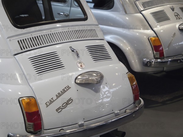 Two white Fiat Abarth vintage cars in an exhibition representing classic automotive history, Cologne, Germany