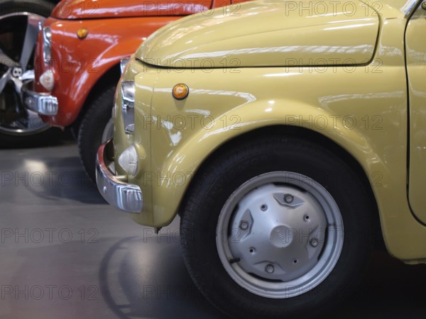 Side view of yellow and red vintage cars arranged in an exhibition, Cologne, Germany