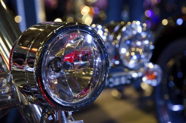 Shiny chrome headlights of a motorbike with light-reflecting backdrop, dortmund, germany