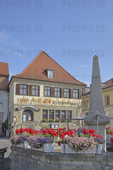 Historic Hotel and Restaurant Schlundhaus, obelisk fountain, market fountain, flower decoration, obelisk fountain, market square, Bad Königshofen, Rhön, Lower Franconia, Franconia, Bavaria, Germany