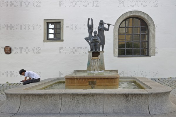 Fountain for civil servants with sculptures Modern art, book reader, flute player, fountain for civil servants, town hall, Haßfurt, Lower Franconia, Franconia, Bavaria, Germany