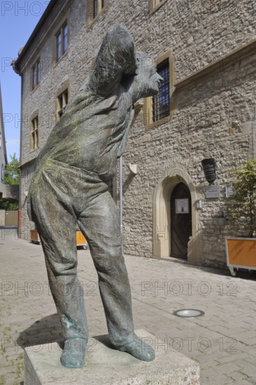 Sculpture Eavesdropper by Karl-Henning Seemann 2007, modern art, listening, hearing, listening, gesture, arm, hand on ear, head, alley, bronze sculpture, standing, life-size, town hall, Marktbreit, Lower Franconia, Franconia, Bavaria, Germany