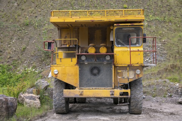 Yellow haul truck in a quarry at summer time