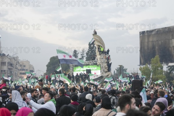 Syrians wave the revolutionary flag and gather in streets and public squares to celebrate the fall of Bashar al-Assad's regime and his escape to Russia. Aleppo, Syria. December 21, 2024, Aleppo, Aleppo, Syria